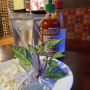 a plate of salad and a bottle of hot sauce