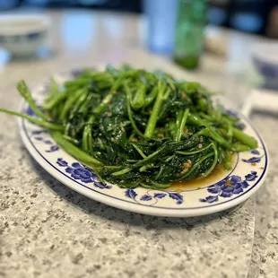 a plate of green vegetables on a table