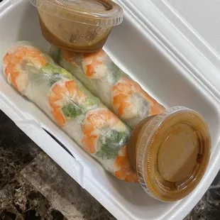 two rolls of food in a styrofoam container