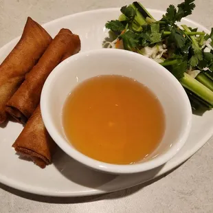 a plate of spring rolls and a bowl of soup