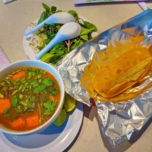 a bowl of soup, tortilla and a plate of salad