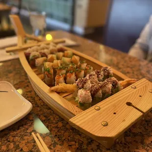 a sushi boat on a table with chopsticks