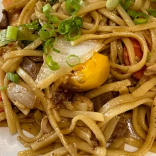 a plate of noodles with meat and vegetables