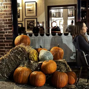 a woman sitting at a table with pumpkins