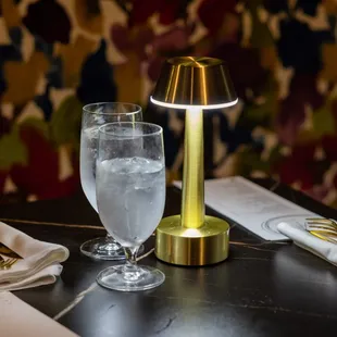a glass of water and a lamp on a table