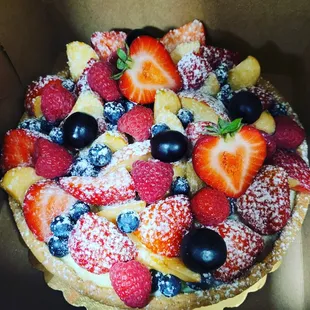a cake with berries and powdered sugar
