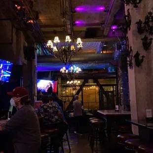 people sitting at tables in a dimly lit restaurant