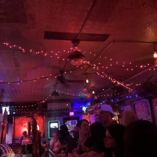 people sitting at a bar with red lights