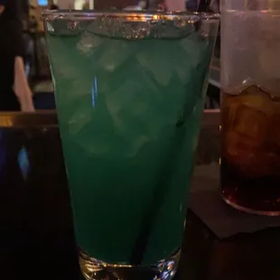 a green drink with a straw in a glass
