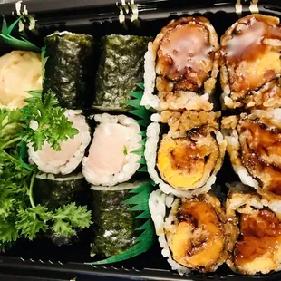 a tray of sushi and vegetables