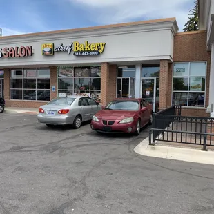 two cars parked in front of a bakery
