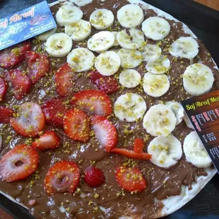 a chocolate pizza with strawberries and bananas