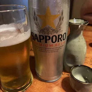 a glass of beer and a can of sapporo