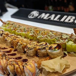 This is an assortment of specialty rolls . Front to back yum yum roll, Cabo roll, hulk roll with tempura shrimp instead of salmon