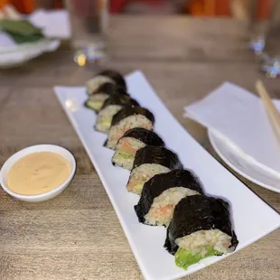 a plate of sushi rolls and dipping sauce
