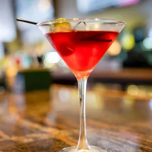 a red cocktail in a martini glass