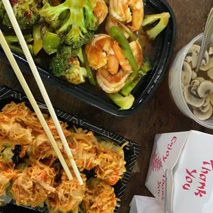 two take out trays of food with chopsticks