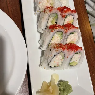a plate of sushi and a bowl of sauce