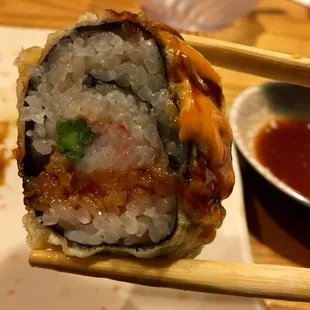 a sushi roll with chopsticks