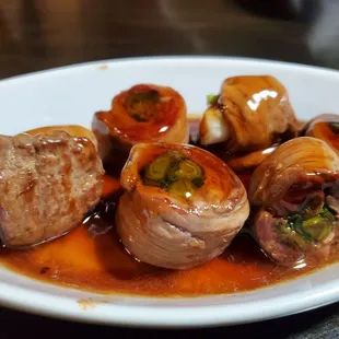a plate of meat wrapped in sauce