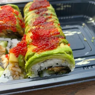 a sushi roll with avocado and sauce