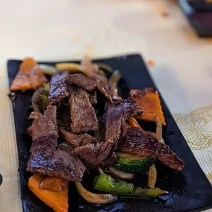 a plate of beef and vegetables on a table