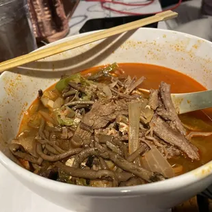 a bowl of food with chopsticks