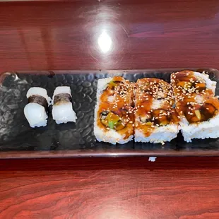 a plate of sushi on a wooden table