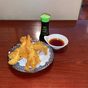 a plate of deep fried food with dipping sauce