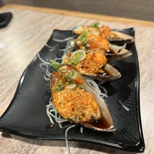 three clams on a black plate