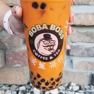 a person holding a cup of boba boba