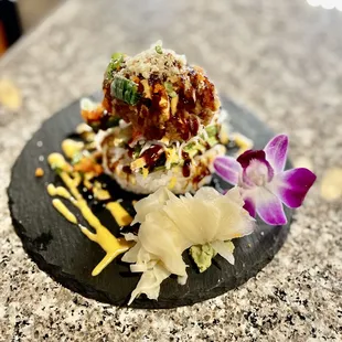 a sushi dish on a black plate