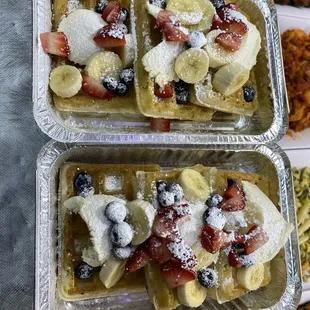 Waffles, strawberries, banana, blueberries, with whipped cream and powdered sugar