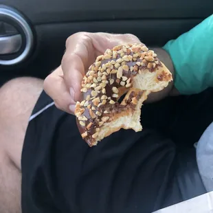 a man holding a half eaten doughnut