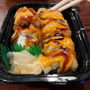 a closeup of a sushi dish with chopsticks