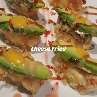 a plate of sushi with avocado and cheese