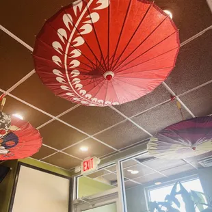 two red umbrellas hanging from the ceiling