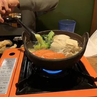 a person stirring food on a stove