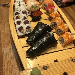 a wooden boat filled with sushi