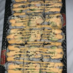 a tray of sushi with sauce on top