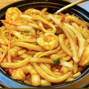a bowl of noodles with shrimp and carrots