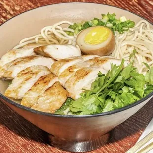 a bowl of ramen with chicken and an egg