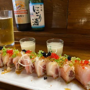 a plate of sushi with a glass of beer