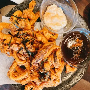 a plate of fried squids with dipping sauce