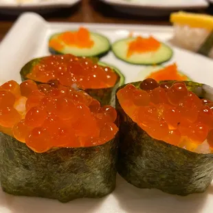 three sushi rolls with salmon roee and cucumber