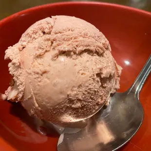 a scoop of ice cream in a red bowl