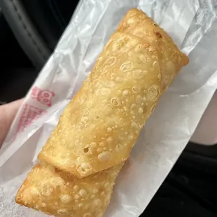a hand holding a fried pastry