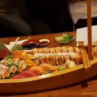 a wooden boat filled with sushi