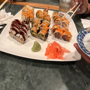 a plate of sushi with chopsticks
