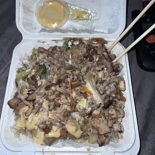 a tray of rice and meat with chopsticks